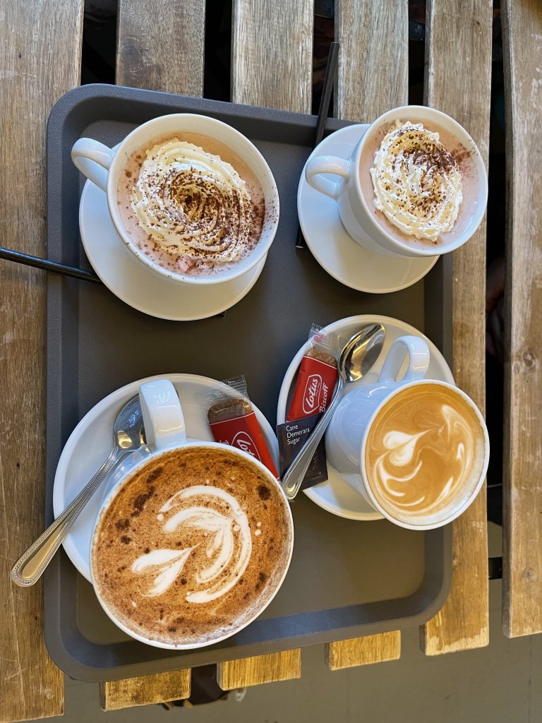 two coffees and two hot chocolates on a tray
