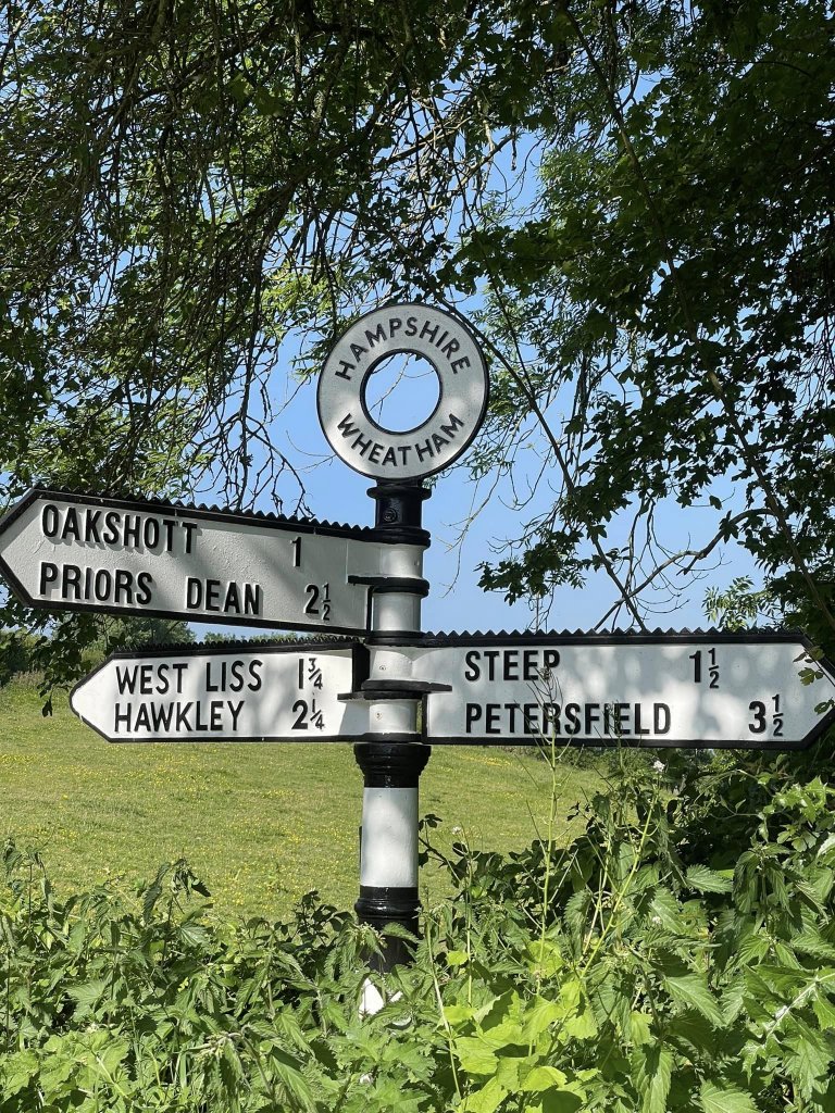 sign giving six directions at a crossroads