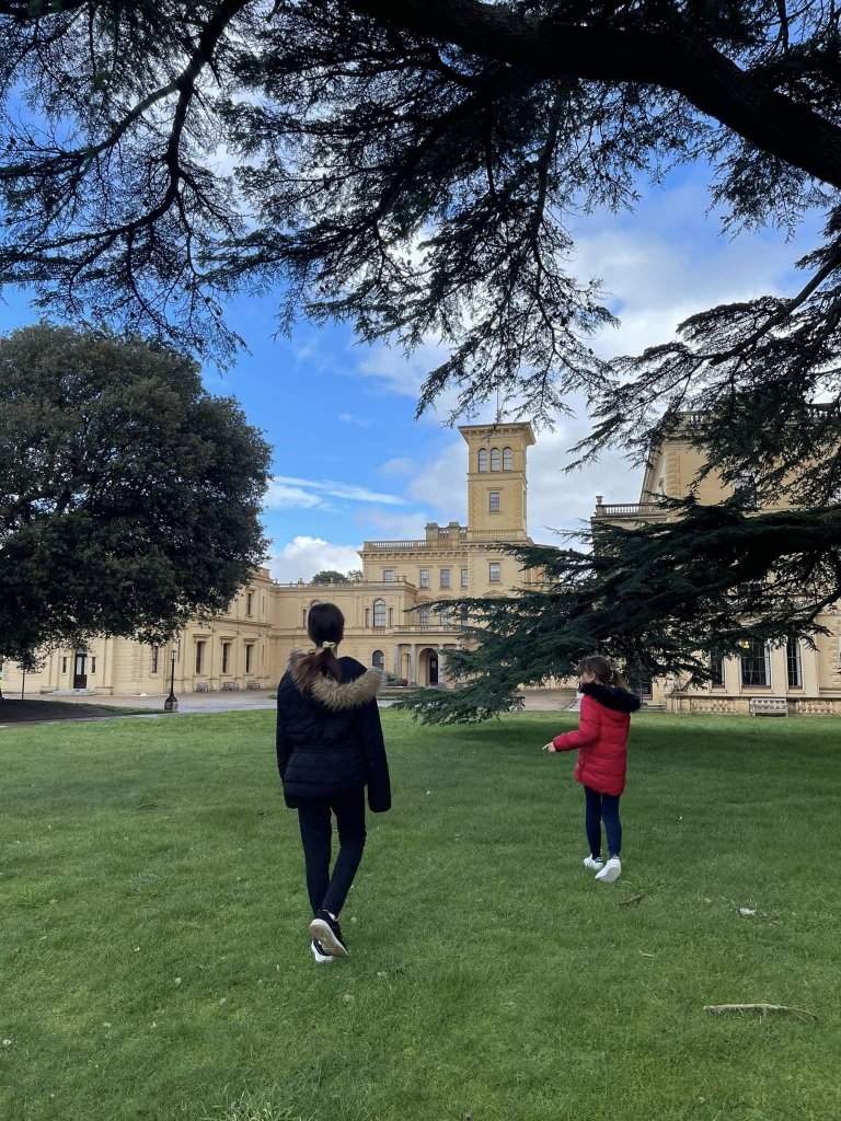 two girls with osbourne house in the background