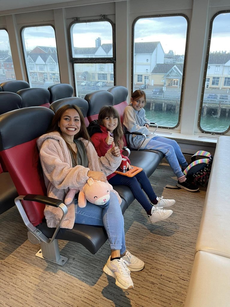 a mum and two daughters sat on a ferry