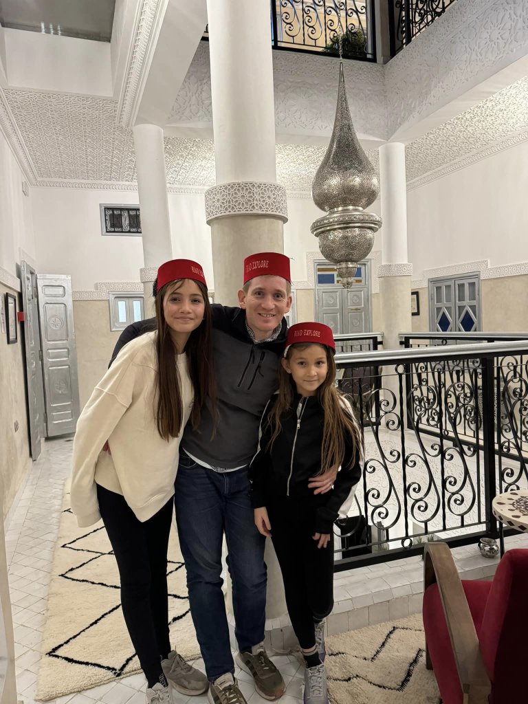 dad and daughters wearing a morrocan hat