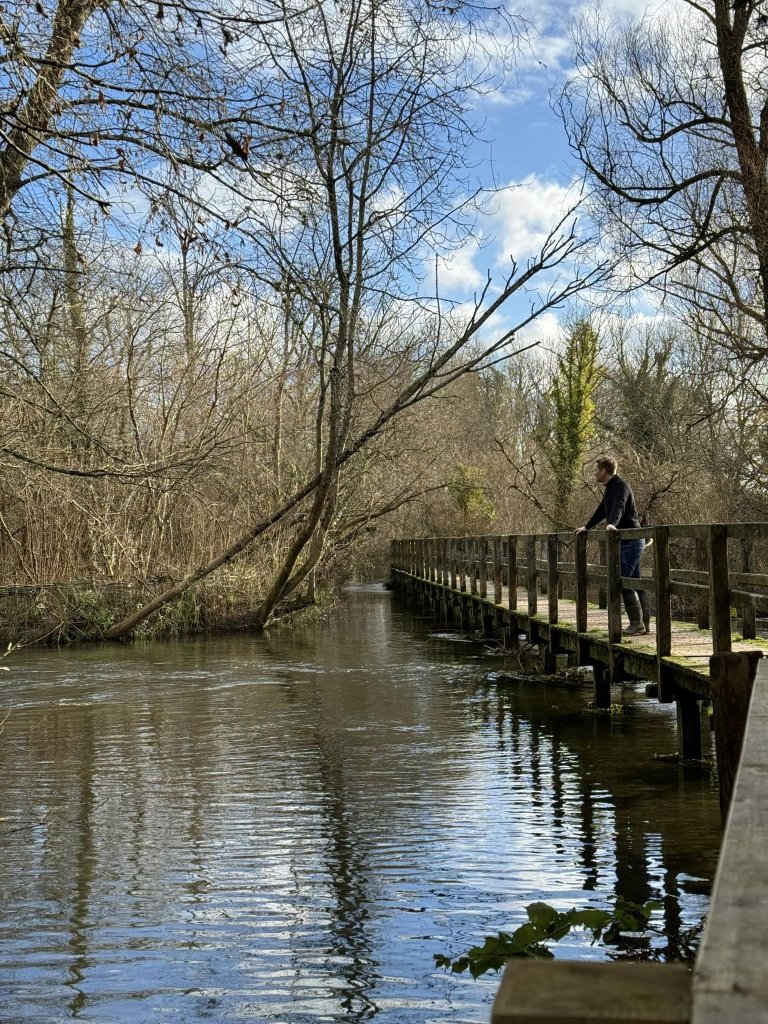Man standing on a bridge above the water
